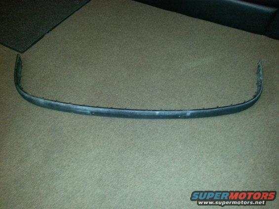 Curved black front bumper trim piece with mounting holes