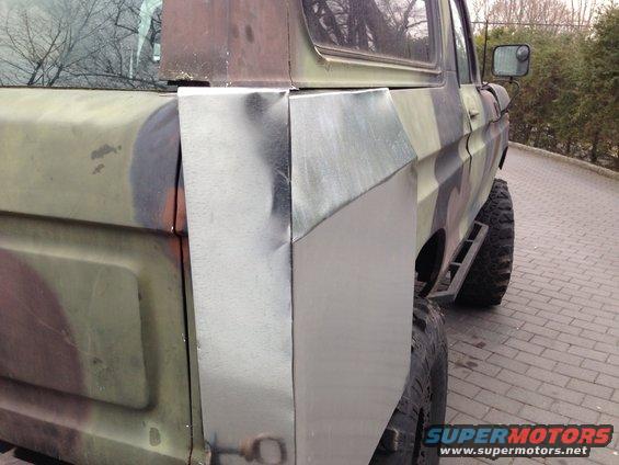 Camouflaged SUV side view with custom metal rear quarter panel repair