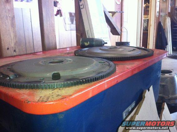Two flywheel assemblies on a blue and orange workbench