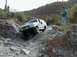 1993 Ford Bronco - White 1993 Ford Bronco tackles a challenging rocky off-road path in a desert environment.
