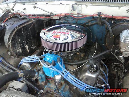 Engine bay of a 1979 Ford Bronco with a Summit Racing air cleaner and blue spark plug wires