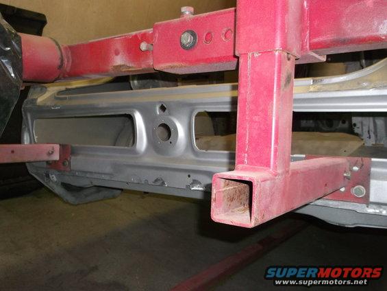 Close-up of car's rear frame section with red metal support structure attached