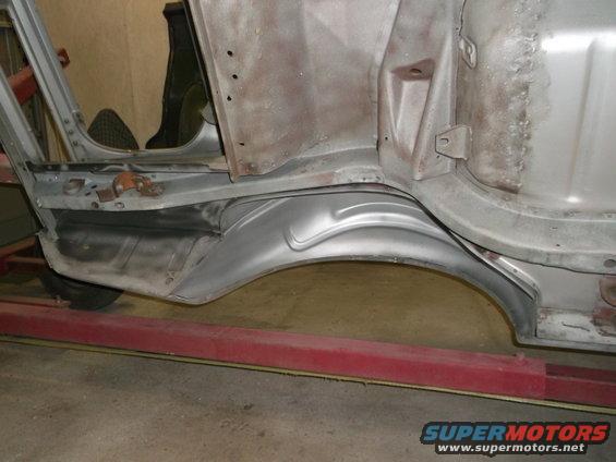 Car body panel and wheel well, bare metal, undergoing restoration