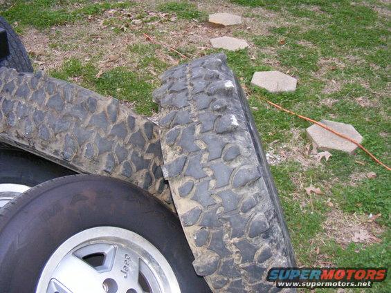 Pile of off-road tires, one with a Jeep wheel