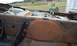 1990 Ford Bronco - Close-up of a heavily rusted truck frame, showing fuel tank and lines, with welding equipment in the background.