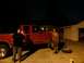1995 Ford F-150 - Two men stand next to a red 1995 Ford F-150 pickup truck at night, with a spare tire on the ground.