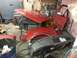 1995 Ford F-150 - Various red truck body panels and a dashboard are stored in a cluttered garage setting.