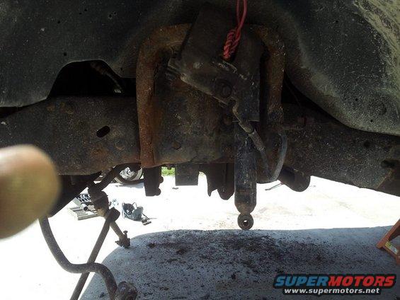 Close-up of rusty truck frame with shock absorber and suspension parts visible
