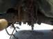 1995 Ford F-150 - Undercarriage view of rusty truck frame and suspension components, possibly undergoing maintenance.