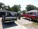 1995 Ford F-150 - Two Ford trucks are parked in a driveway, one is on jack stands with a welding setup nearby.