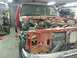 1995 Ford F-150 - The front of a red truck is dismantled, revealing the engine and radiator components.