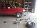 1995 Ford F-150 - A red 1995 Ford F-150 truck is parked in a garage, surrounded by various tools and a spare tire, suggesting ongoing maintenance or repair.