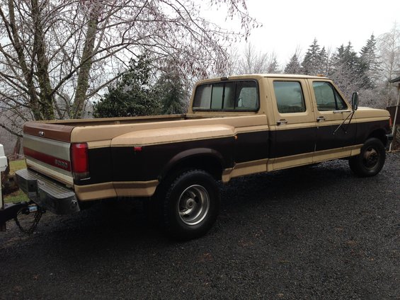 Two-tone brown and tan Ford F-350 pickup truck, crew cab, long bed, dual rear wheels, with a trailer hitch