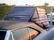 1972 Ford Ranchero - A unique camper shell is mounted on the rear of a car, with another vehicle partially visible in the background.