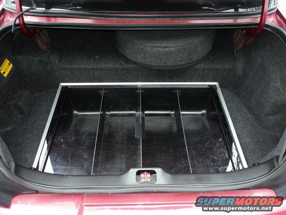 Trunk of a 2004 Mercury Grand Marquis with a spare tire and a black organizer tray
