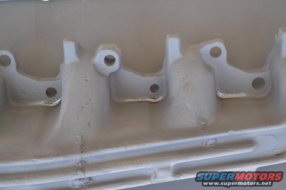 Gray exhaust manifold with visible bolt holes and casting details