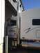 2003 Peterbilt 379 - A white semi-truck cab is parked next to a white trailer, with a large chrome exhaust pipe visible.