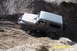 1990 Ford Bronco - A Jeep Wrangler Rubicon navigates a challenging dirt incline, demonstrating its off-road capabilities.