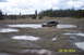 1990 Ford Bronco - A Jeep Wrangler navigates through a muddy off-road area under a cloudy sky.