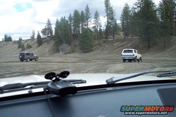 White 1990 Ford Bronco rear view on dirt road