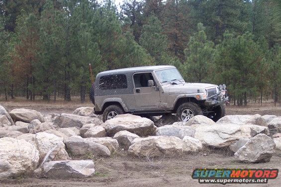 Jeep Wrangler Rubicon with aftermarket bumper navigating a rocky trail