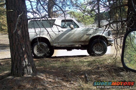 White 1990 Ford Bronco side view, muddy, off-road