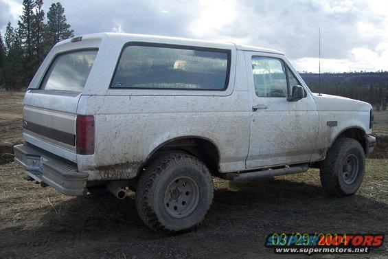 White 1990 Ford Bronco side view, covered in mud