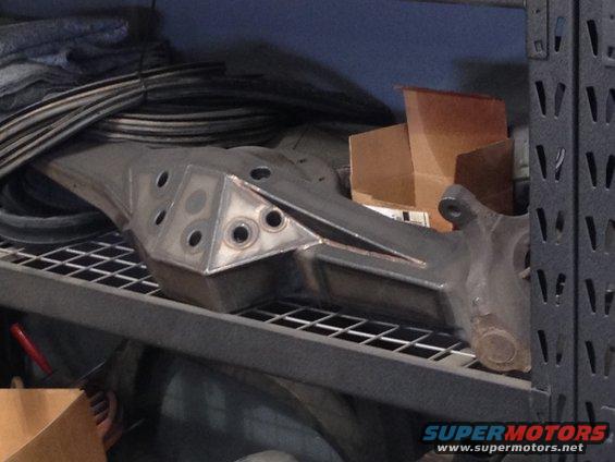 Custom fabricated suspension part on a shelf, metal, with triangular gussets and holes