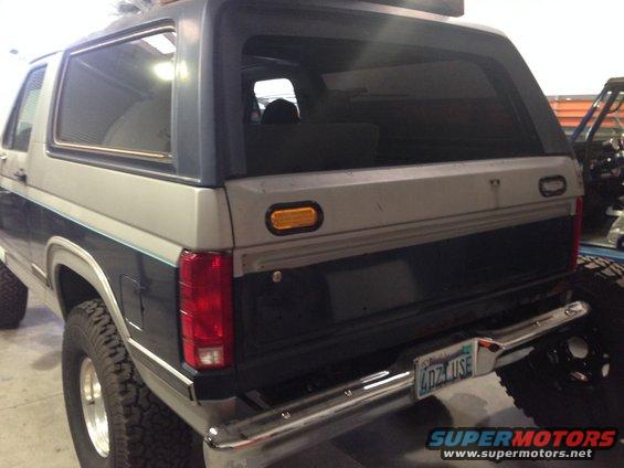 Rear view of a blue and gray Ford Bronco with a chrome bumper and a license plate reading 4DZ U5E