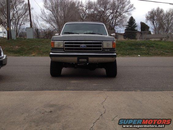 Front view of a dark gray 1990 Ford Bronco with a chrome grille and 4x4 badging