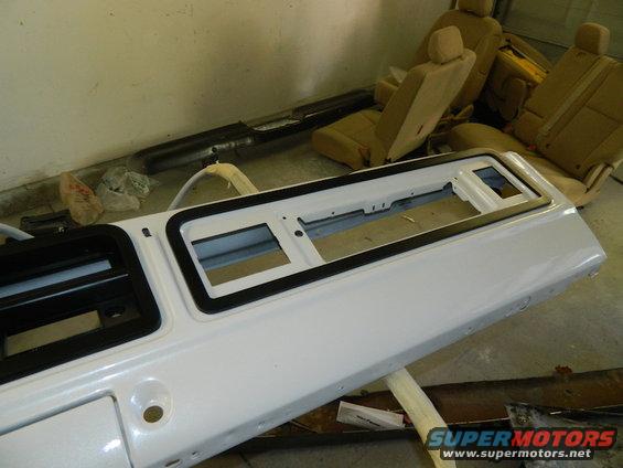 White dashboard panel and tan car seats are in a garage