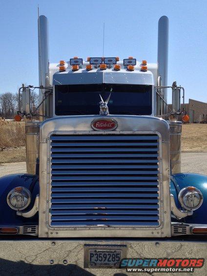 Blue Peterbilt 379 truck front view with chrome grille and exhaust stacks