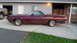 1972 Ford Ranchero - A maroon 1972 Ford Ranchero is parked in front of a house, with a pickup truck visible to its left.