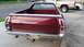1972 Ford Ranchero - Rear view of a maroon 1972 Ford Ranchero parked on a driveway with other vehicles in the background.