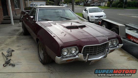 Maroon 1972 Ford Ranchero with hood scoop, parked on concrete