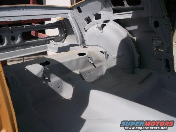 1967 Ford Mustang interior, primer gray, showing floor pan and rear wheel wells