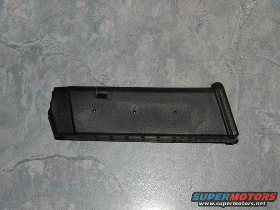 Black gun magazine on a textured gray surface