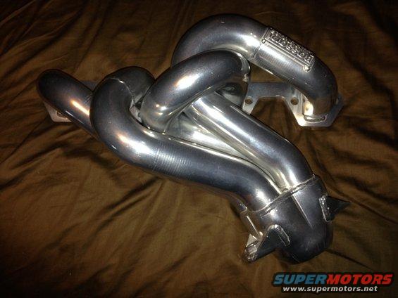 Chrome exhaust manifold with 'BASSANI' logo visible