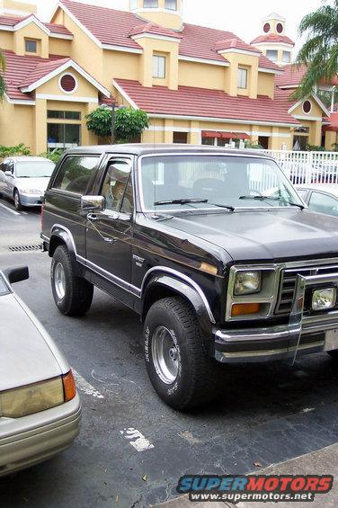 Black Ford Bronco parked next to a silver sedan, front quarter view