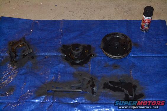 Automotive parts and spray paint on blue tarp