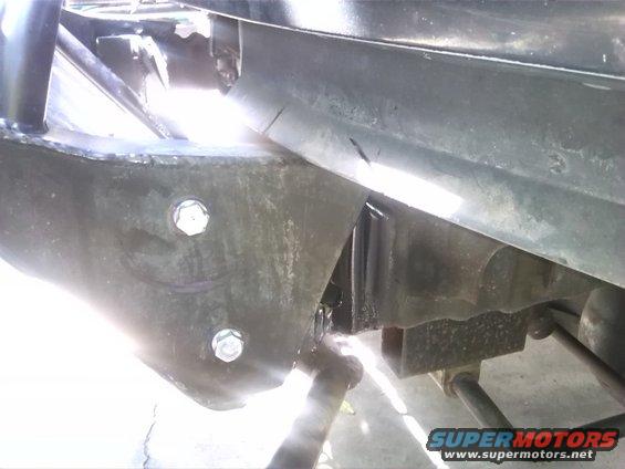 Close-up of vehicle frame with bolts and suspension parts visible