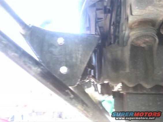 Undercarriage of a vehicle with visible suspension components and a Supermotors.net watermark