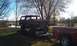 1978 Ford Bronco - Rusty 1978 Ford Bronco loaded onto a trailer, hitched to a red pickup truck.