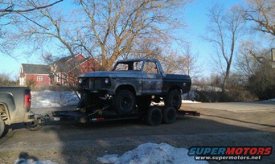 Gray and black 1978 Ford Bronco on a trailer, front end removed, side view