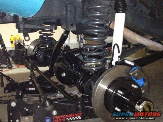 Front suspension and brake assembly with black springs and white shock absorber