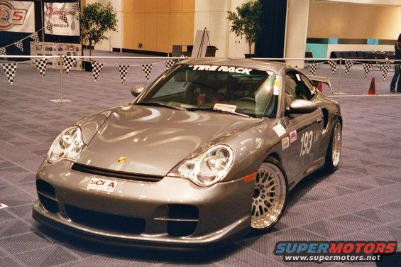 Gray Porsche 911 Turbo with racing decals and 'Tire Rack' banner on windshield