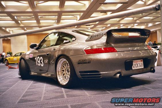 Gray Porsche 911 GT2 with racing decals and a large rear spoiler, viewed from the rear three-quarter angle