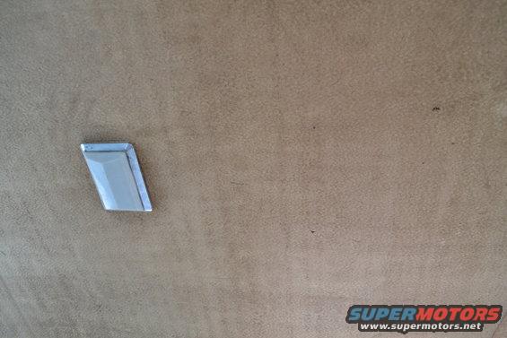 Close-up of a chrome trim piece on a tan interior surface