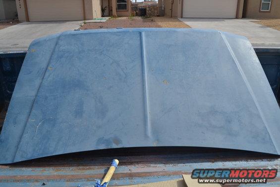 Blue truck hood resting in truck bed