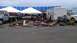1973 Chevrolet Camaro - Various automotive parts are laid out for sale at an outdoor market with tents and stadium seating in the background.